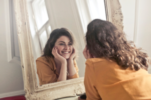 woman looking at the mirror smiling